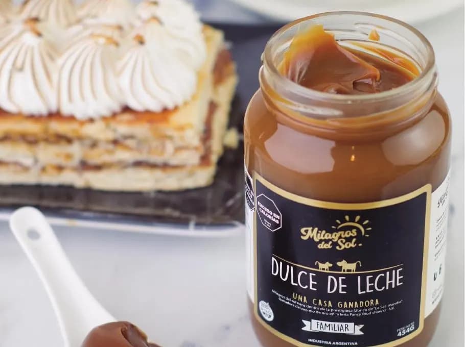 Frasco de dulce de leche Milagros del Sol junto a una torta